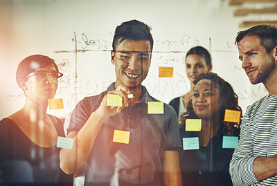 Buy stock photo Cropped shot of a group of young designers using sticky notes during a brainstorming session