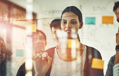 Buy stock photo Cropped shot of a group of young designers using sticky notes during a brainstorming session