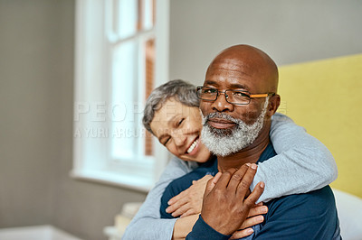 Buy stock photo Shot of a senior married couple embracing each other at home