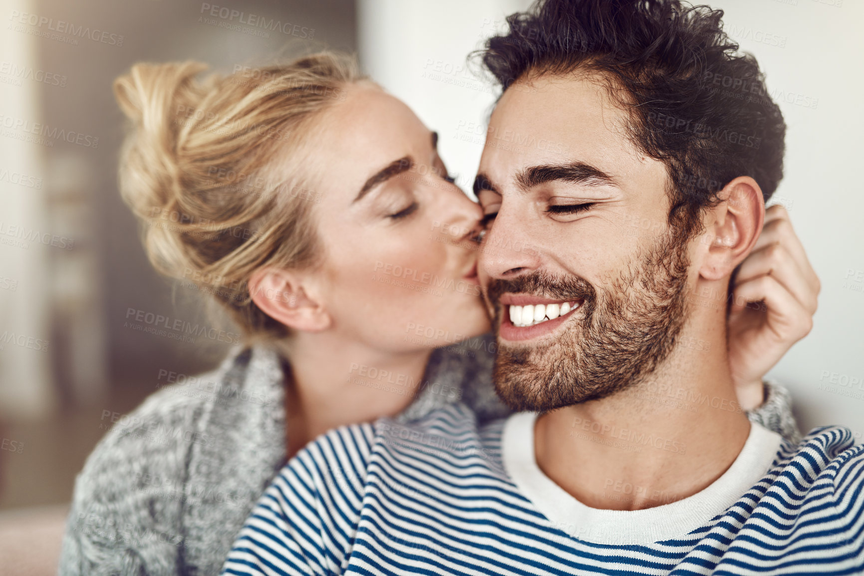 Buy stock photo Cropped shot of an affectionate young couple relaxing at home