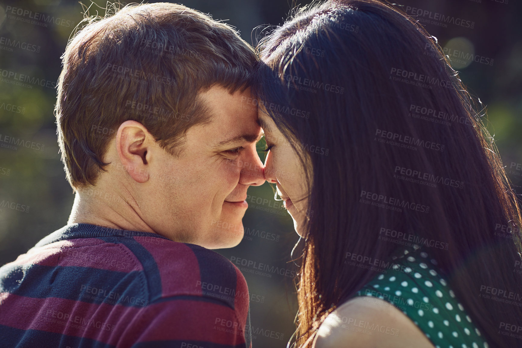 Buy stock photo Shot of an affectionate young couple spending time together outdoors