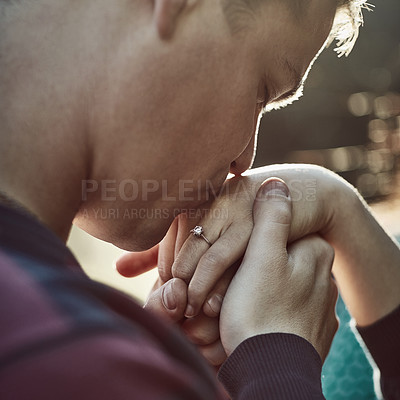 Buy stock photo Shot of a young man affectionately kissing his girlfriend’s hand outdoors