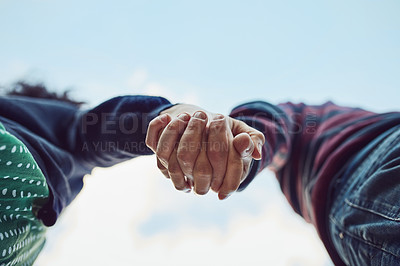 Buy stock photo Low angle shot of an affectionate couple holding hands outdoors