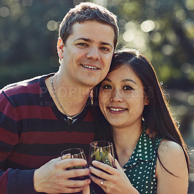 Buy stock photo Portrait of a happy young couple enjoying some wine together outdoors