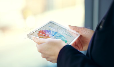 Buy stock photo Cropped shot of an unrecognizable young businesswoman working on a digital tablet while standing on her office balcony