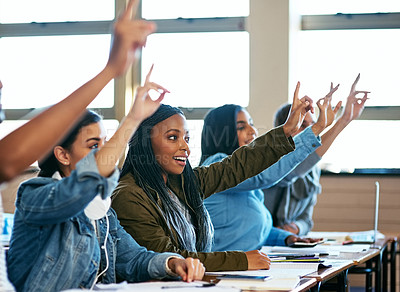 Buy stock photo Cropped shot of a group of university students sitting with their hands raised in class