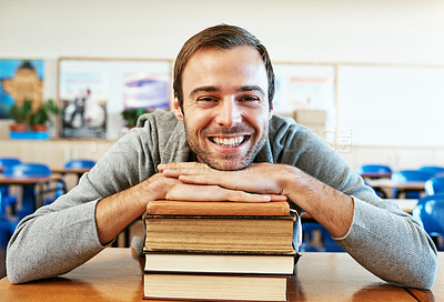 Buy stock photo Cropped portrait of a handsome young university student leaning on his textbooks while sitting in class