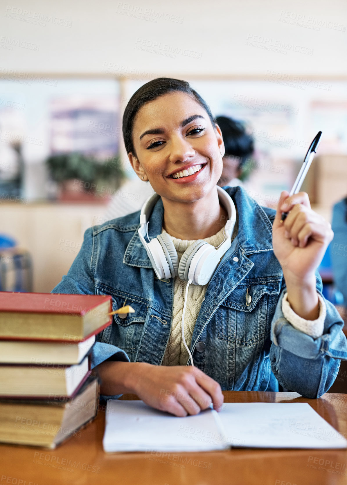 Buy stock photo Cropped portrait of an attractive young university student sitting in class with her hand raised