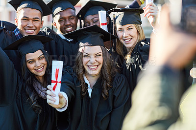 Buy stock photo Shot of a group of students getting their photo taken on graduation day