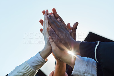 Buy stock photo Closeup shot of a group of unrecognisable students high fiving on graduation day