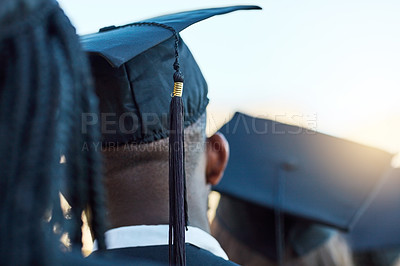 Buy stock photo Rearview shot of a group of students standing in a line on graduation day