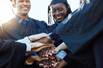 Buy stock photo Shot of a group of students joining their hands together on graduation day