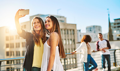 Buy stock photo Shot of young female friends taking a selfie outside