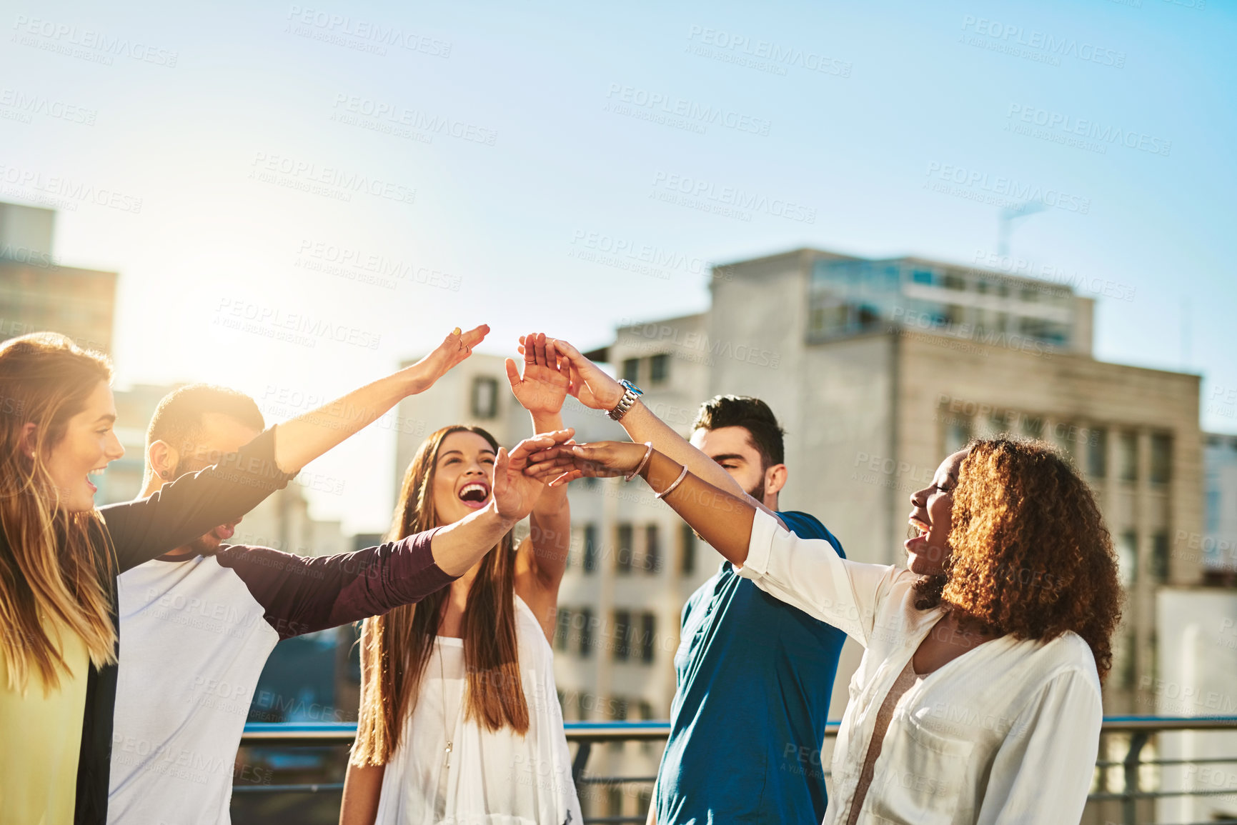 Buy stock photo Cropped shot of a group of young people putting their hands together in unity outside