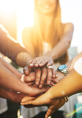 Buy stock photo Cropped shot of an unrecognizable group of people putting their hands together in unity outside