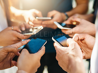 Buy stock photo Shot of unrecognizable people using smartphones outside