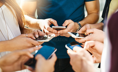 Buy stock photo Shot of unrecognizable people using smartphones outside