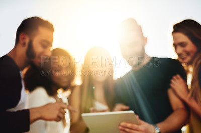 Buy stock photo Shot of young friends using a tablet outside