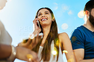 Buy stock photo Shot of a beautiful young woman on a call outside