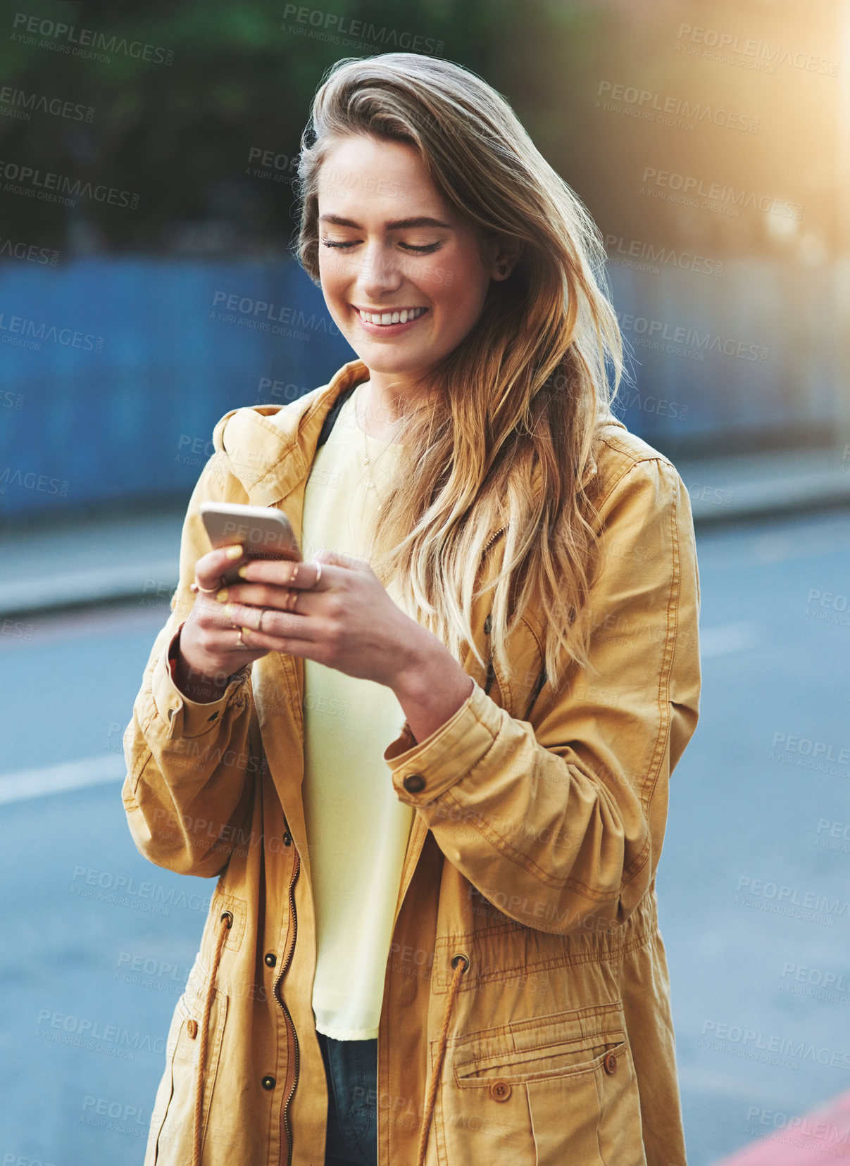 Buy stock photo Shot of a young woman using her cellphone while out in the city