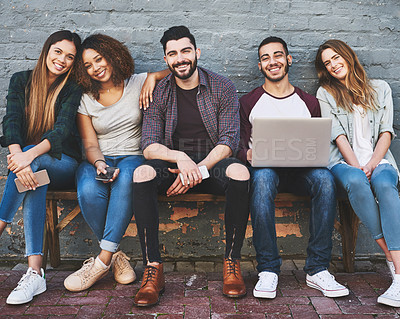 Buy stock photo Portrait of a group of young friends using their wireless devices together outdoors