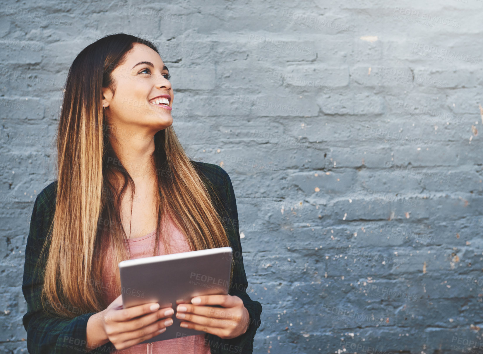 Buy stock photo Smile, tablet and thinking with designer woman on brick wall background for creative research. Project management, space and technology with happy employee outdoor for professional web development