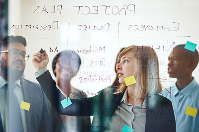 Buy stock photo Business people, glass wall and woman writing, planning and strategy in office. Sticky notes, brainstorming ideas and group of employees working on project, schedule and collaboration for teamwork.