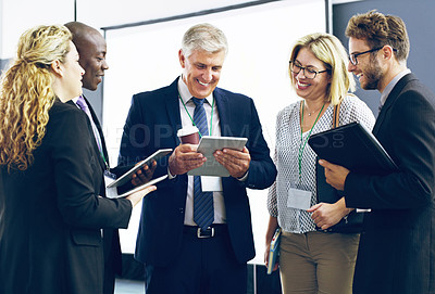Buy stock photo Cropped shot of a group of corporate businesspeople standing in a huddle with digital tablets in hand