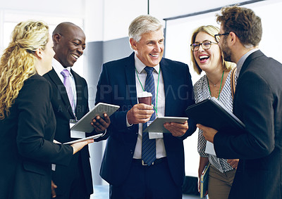 Buy stock photo Cropped shot of a group of corporate businesspeople standing in a huddle with digital tablets in hand