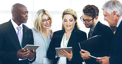 Buy stock photo Cropped shot of a group of corporate businesspeople standing in a huddle with digital tablets in hand