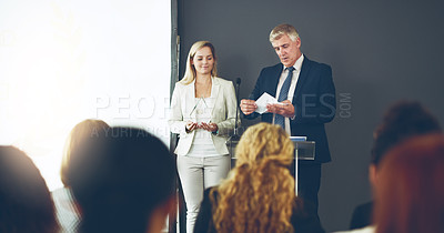 Buy stock photo Cropped shot of two corporate businesspeople reading out the names of recipients during a ceremony