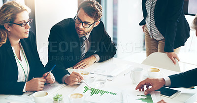 Buy stock photo High angle shot of a group of corporate businesspeople looking at paperwork in the boardroom