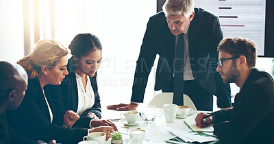 Buy stock photo Cropped shot of a group of corporate businesspeople looking at paperwork in the boardroom
