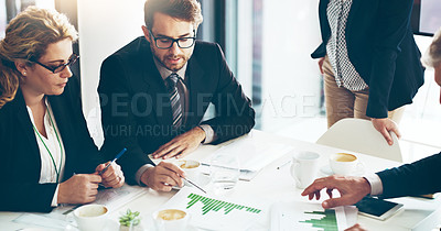 Buy stock photo High angle shot of a group of corporate businesspeople looking at paperwork in the boardroom