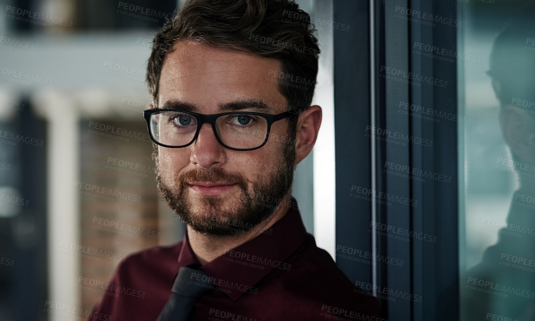 Buy stock photo Portrait of a confident young businessman standing in a modern office