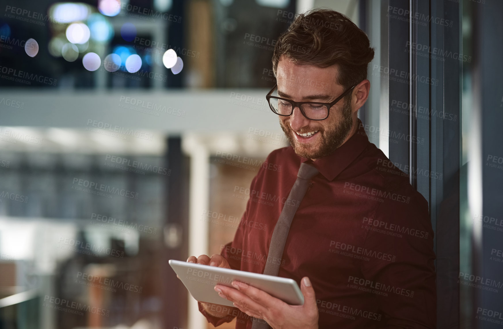 Buy stock photo Shot of a young businessman using a digital tablet in a modern office