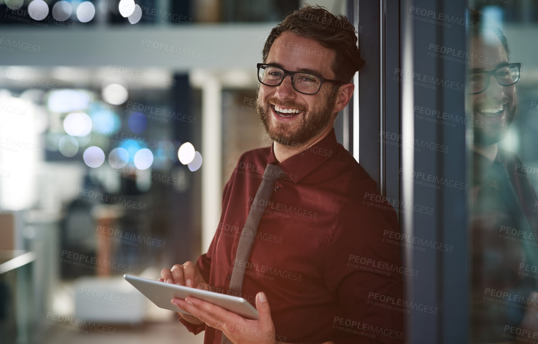 Buy stock photo Shot of a young businessman using a digital tablet in a modern office