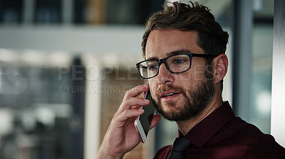 Buy stock photo Shot of a young businessman using a mobile phone in a modern office