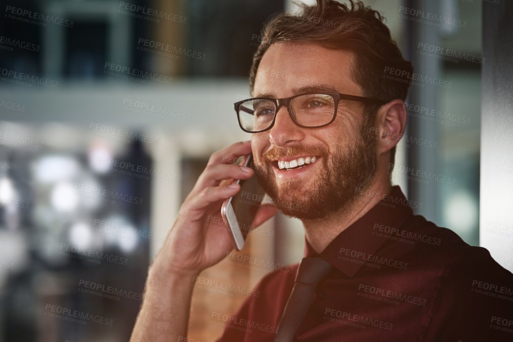 Buy stock photo Shot of a young businessman using a mobile phone in a modern office