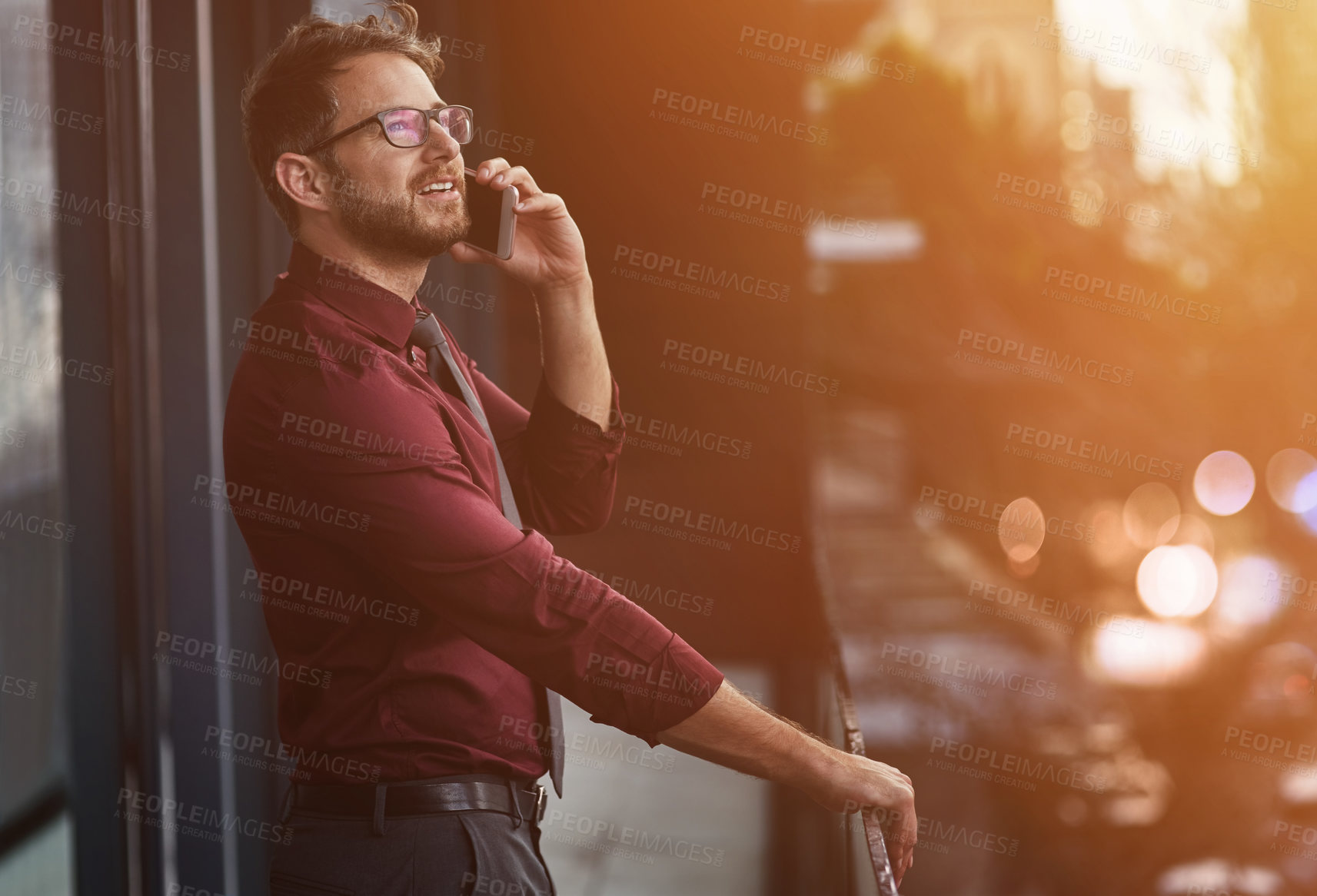 Buy stock photo Shot of a young businessman using a mobile phone on the balcony of an office