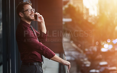 Buy stock photo Shot of a young businessman using a mobile phone on the balcony of an office