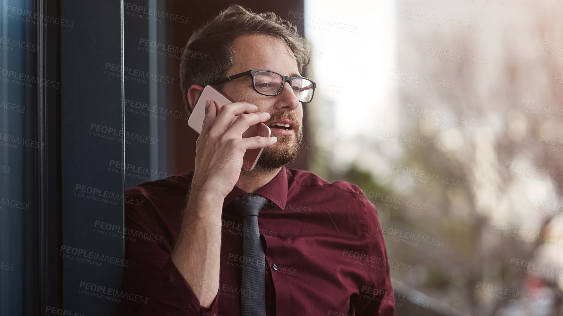 Buy stock photo Shot of a young businessman using a mobile phone on the balcony of an office