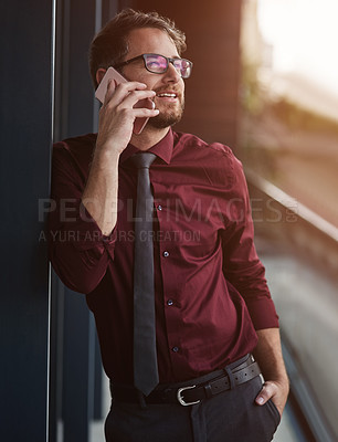 Buy stock photo Shot of a young businessman using a mobile phone on the balcony of an office