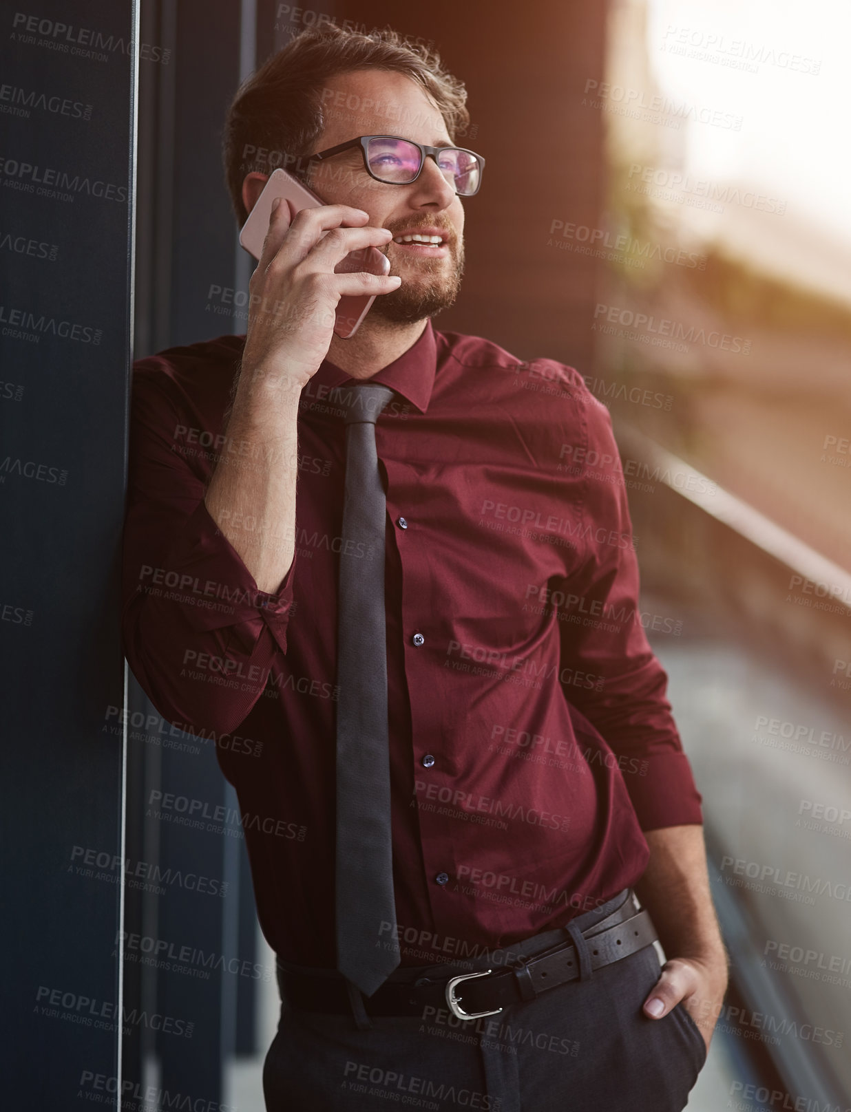 Buy stock photo Shot of a young businessman using a mobile phone on the balcony of an office