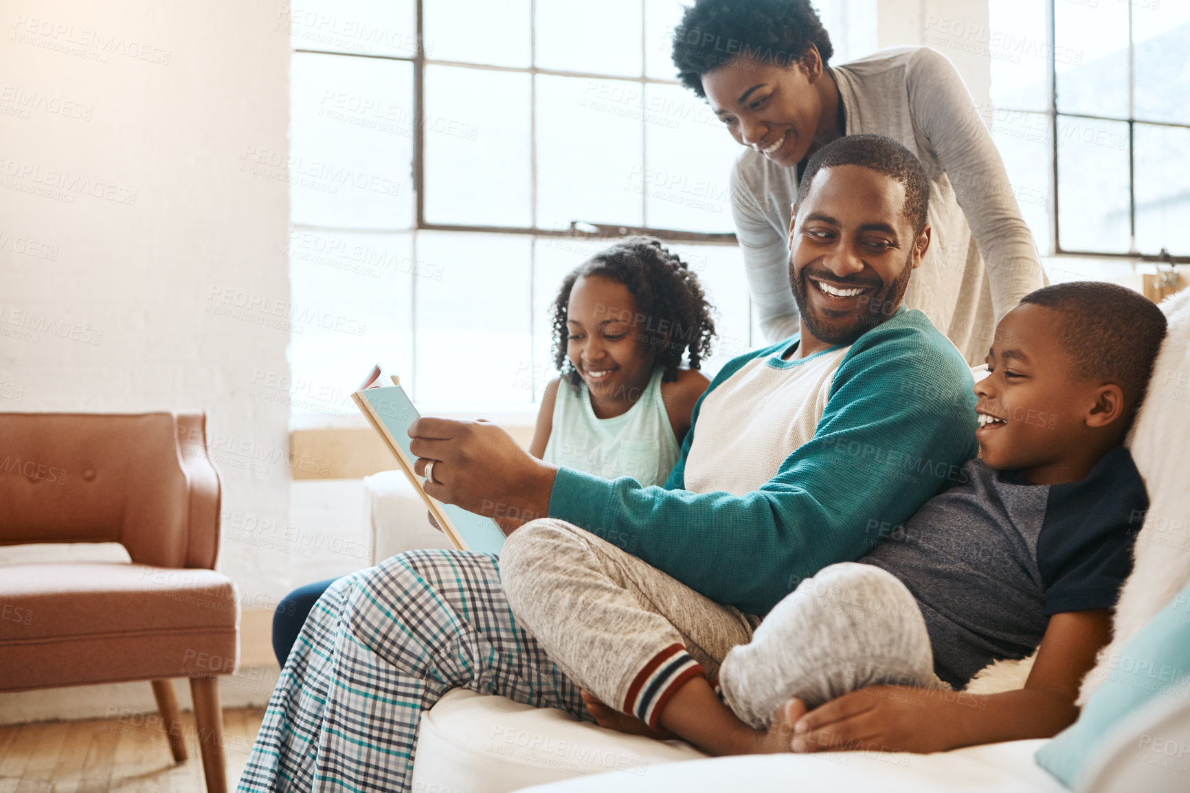 Buy stock photo Reading, bonding and black family with story on sofa for time together on fathers day at home. Smile, knowledge and African parents relaxing with children in living room with fantasy book or novel.