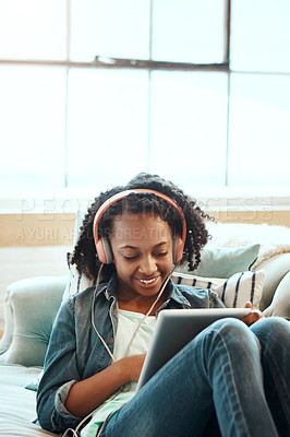 Buy stock photo Cropped shot of a young girl chilling on the sofa with her tablet indoors