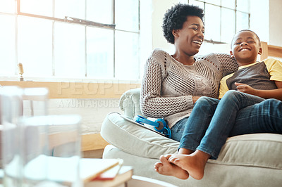 Buy stock photo Family, mother and son relax on a sofa, laughing and happy while bonding in a home together. Mom, love and boy resting with his parent, content and playful while sitting and talking in a living room