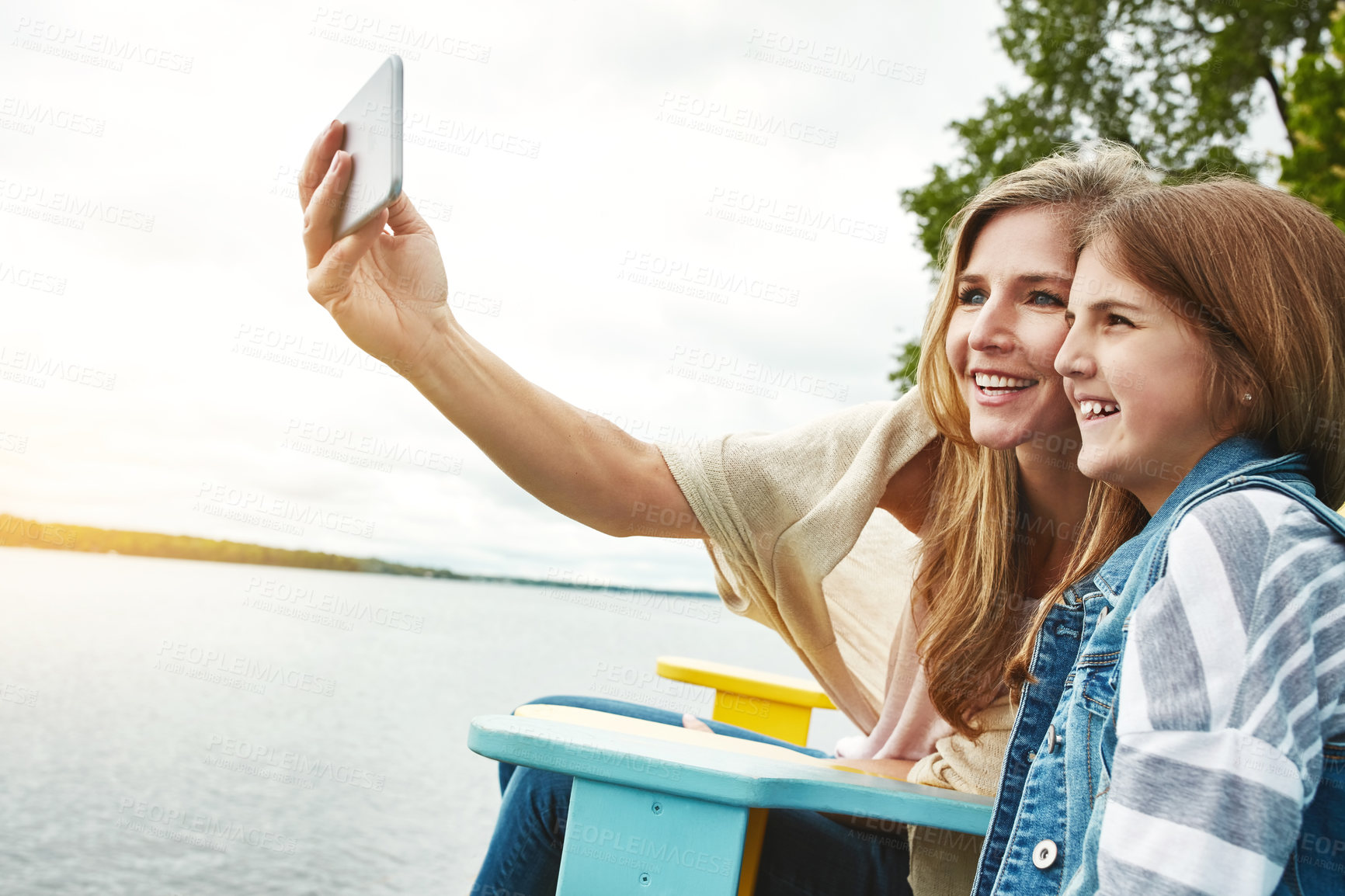 Buy stock photo Shot of a mother and her daughter taking a selfie together outdoors