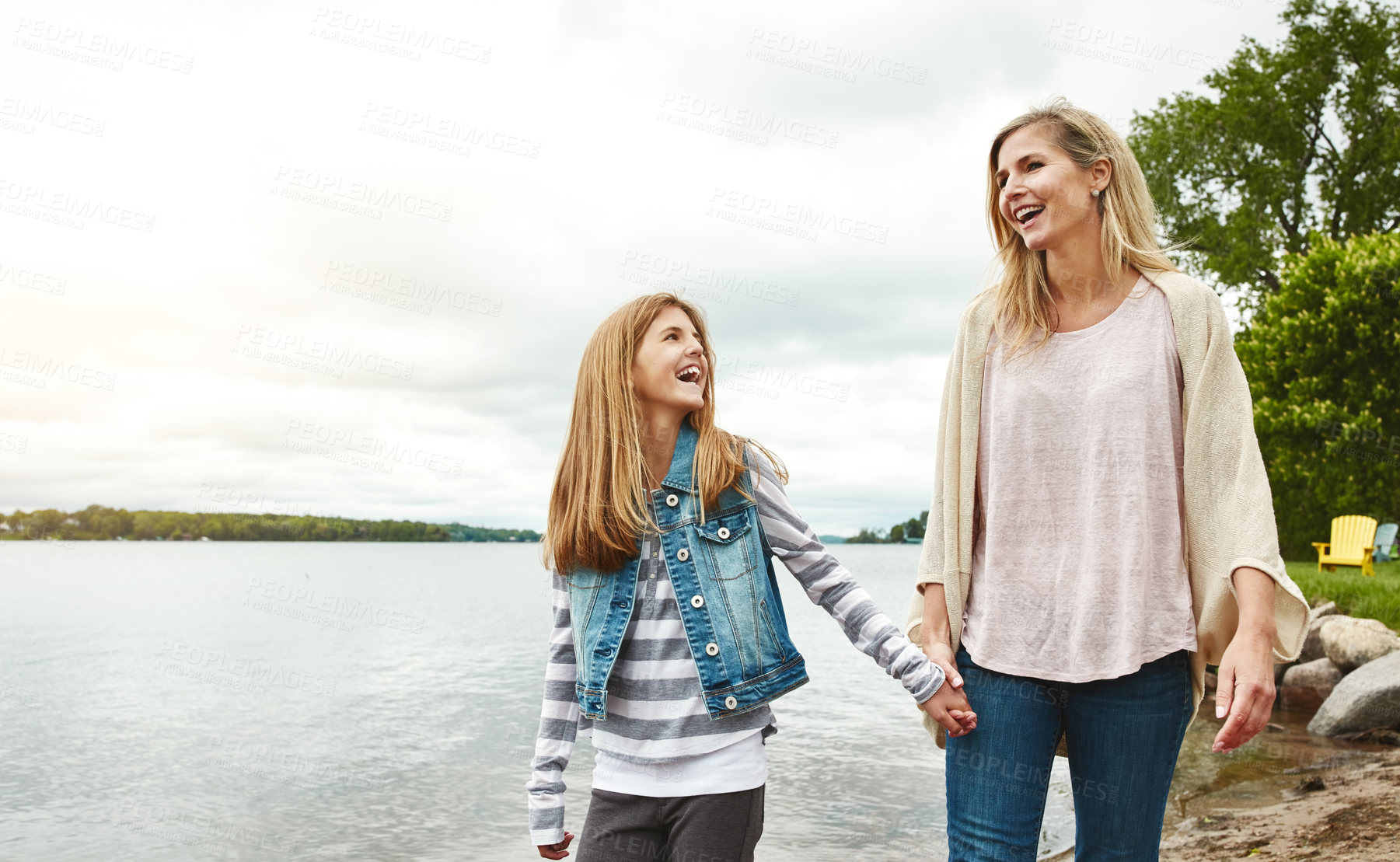 Buy stock photo Holding hands, lake or security with mother and daughter outdoor in nature together for bonding. Family, love or summer with woman and girl child walking by water in park for support or trust