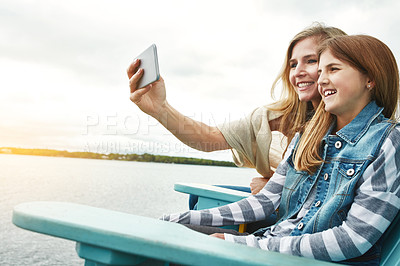 Buy stock photo Shot of a mother and her daughter taking a selfie together outdoors